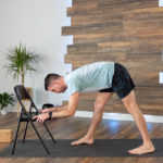 Garrett practices Pyramid pose using a chair in front of him